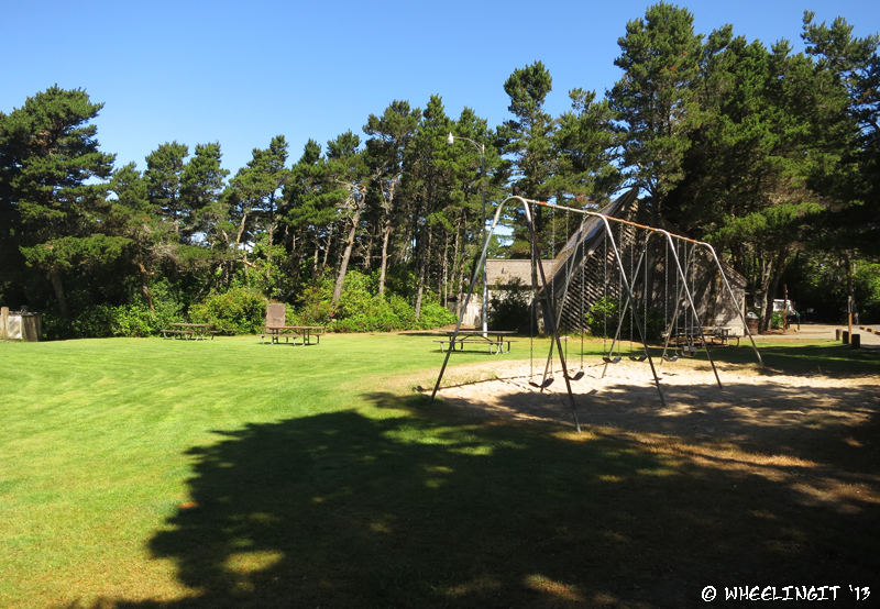 View of grassy lawn, play area and facilities (in back)