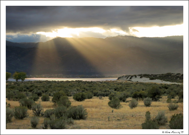 Rays of sun peek through on a dark, cloudy evening