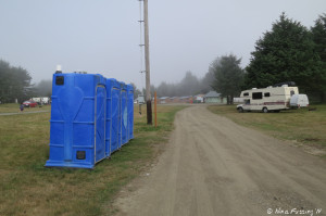 View down towards entry of dispersed camping area. Porta porties on the left. RV is parked on the right.